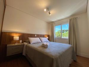 ein Schlafzimmer mit einem Bett mit zwei Handtüchern darauf in der Unterkunft Apartamentos Residencial Villa Rossa by Achei Gramado in Gramado + 81 Fotos