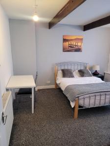 um quarto com uma cama, uma mesa e uma secretária em No 2 Decent Home -Large Deluxe bedroom em Dukinfield