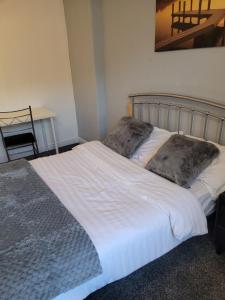 a bed with two pillows on it in a room at No 2 Decent Home -Large Deluxe bedroom in Dukinfield