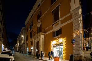 un grupo de personas caminando por una calle por la noche en BF Glam-Apartments, en Perugia