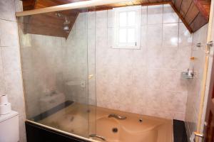 a shower with a glass door in a bathroom at Chale com otima localizacao em Domingos Martins ES in Domingos Martins +30 photos