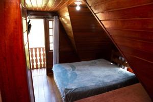 a small bedroom with a bed in a wooden house at Chale com otima localizacao em Domingos Martins ES in Domingos Martins