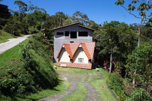 a small house on a hill next to a road at Chale com otima localizacao em Domingos Martins ES in Domingos Martins