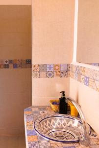 um lavatório de casa de banho com um dispensador de sabão em Dar Mouja, eco-friendly home em Imsouane