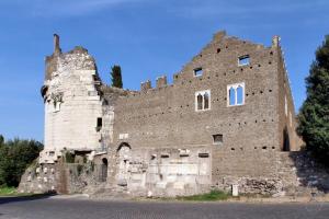 un vecchio edificio in pietra con un cielo blu sullo sfondo di Appia Park Apartment a Roma