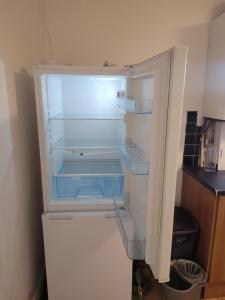 an empty refrigerator with its door open in a kitchen at No 2 Decent Home -Large Deluxe bedroom in Dukinfield