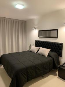 a bedroom with a large bed with a black blanket at Departamento Green Park in Punta del Este