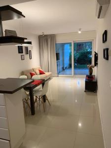 a kitchen and living room with a table and a couch at Departamento Green Park in Punta del Este