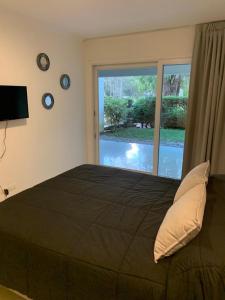 a bedroom with a large bed and a large window at Departamento Green Park in Punta del Este