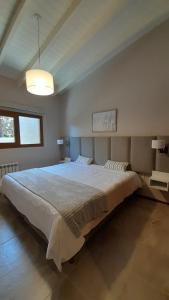 ein Schlafzimmer mit einem großen weißen Bett in einem Zimmer in der Unterkunft Aires del Sur in Dina Huapi