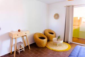 uma sala de estar com cadeiras de vime e uma mesa em Dar Mouja, eco-friendly home em Imsouane