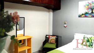 a bedroom with a bed and a chair and a mirror at Hospedaje Aldana - Apartamento AMAL zona centro in Tuxpan de Rodríguez Cano