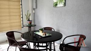 a black dining room table with chairs and a cat on a plate at Hospedaje Aldana - Apartamento AMAL zona centro in Tuxpan de Rodríguez Cano