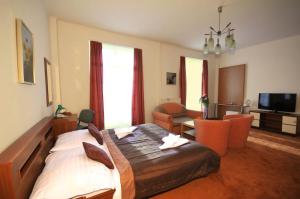 a bedroom with a large bed and a living room at Hotel Palace in Nový Smokovec