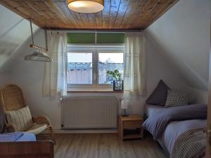 1 dormitorio con cama y ventana en Spatzennest und Rabennest, en Sugenheim