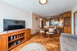 sala de estar con TV y mesa con sillas en Rivadavia 138 - B Centro - Elegante con Balcón y Vista en Córdoba