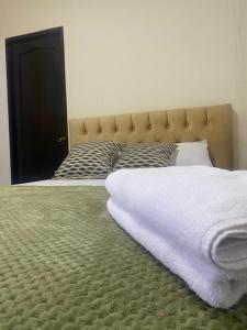 Una cama con una manta blanca encima. en Habitación Matrimonial en montañita, en Montañita