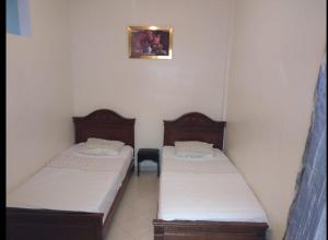 two twin beds in a room with at Appartement meublé près du grand souk Elhad in Agadir