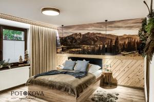 um quarto com uma cama com um quadro na parede em Potokova apartament Centrum em Zakopane