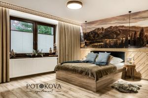 a bedroom with a bed with a painting on the wall at Potokova apartament Centrum in Zakopane