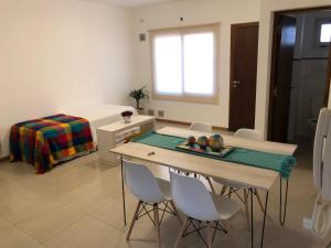 Habitación con mesa, sillas y cama en Departamento Bombal Sur en Godoy Cruz