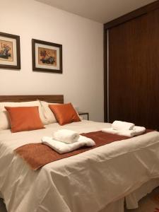 1 dormitorio con 1 cama con toallas en Departamento Bombal Sur en Godoy Cruz