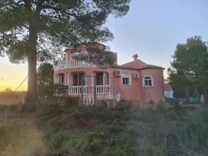 une maison rose assise au sommet d'une colline dans l'établissement Château Angélique, à Valence