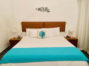 una camera da letto con un grande letto con una coperta blu e bianca di Sublime Love Private Beach a Santa Bárbara de Samaná