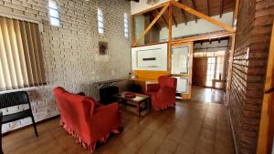 sala de estar con sillas rojas y mesa en Casa Simona en San Rafael