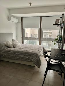 a bedroom with a bed and a chair and a window at Departamento Centro Esmeralda 11 in Buenos Aires