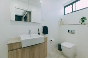 a bathroom with a sink and a toilet at ‘The Lumos’ Designer home Close to Olympic Park in Sydney