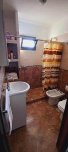 baño con lavabo y aseo y ventana en La Estancita de Tanti con pileta in 