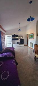 ein Wohnzimmer mit lila Kissen auf einem Sofa in der Unterkunft La Estancita de Tanti con pileta in Tanti