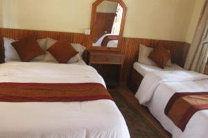 Rúm í herbergi á Chitwan Forest Resort , Chitwan National Park
