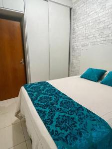 Un dormitorio con una cama grande con sábanas azules. en Massagua House, en Caraguatatuba