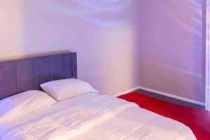 - une petite chambre avec un lit blanc et un tapis rouge dans l'établissement Modern 1 BR APT w/ Pool, Tennis court, Wi-Fi, & AC, à Monroeville