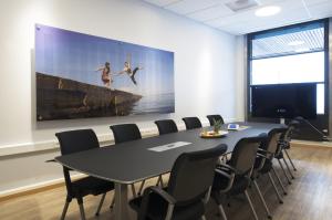 a conference room with a table and chairs and a large painting at Thon Hotel Opera in Oslo