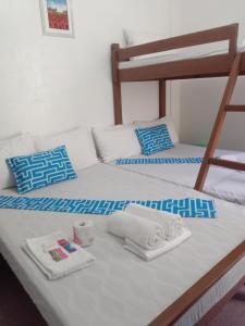 a bed with two bunk beds with towels on it at Bucana beachfront guesthouse in El Nido