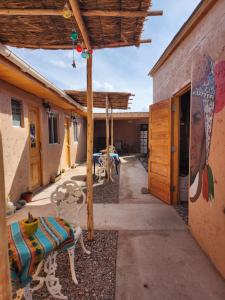 un patio con un banco y un mural en el lateral de un edificio en Las Casas Hostel Atacama en San Pedro de Atacama