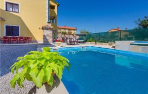 a swimming pool in front of a house at Awesome Home In Nedescina With Outdoor Swimming Pool in Nedeščina