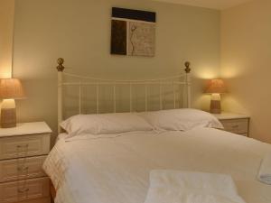 a bedroom with a white bed with two lamps at Caedmons Dream in Whitby