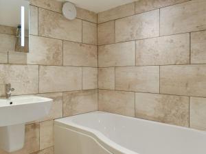 a bathroom with a tub and a sink at Caedmons Dream in Whitby