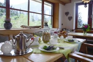 einen Tisch mit einem Wasserkocher und Teller mit Lebensmitteln in der Unterkunft Dreimäderlhaus am Berg in Pfronten