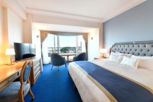 a hotel room with a large bed and a desk at Hotel New Grand in Yokohama