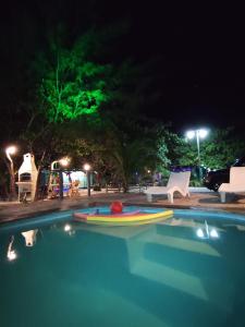 福廷的住宿－Chalés da Cris，游泳池在晚上,里面装有冲浪板