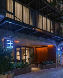 胡志明市的住宿－Triple E Hotel Metro Ben Thanh，酒店入口前面设有桌子