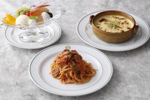 a table with three plates of pasta and a pot of soup at Hotel New Grand in Yokohama