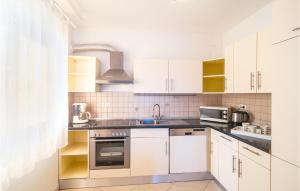 una cocina con armarios blancos y fregadero en Beautiful Apartment In Stanici With House Sea View en Celina