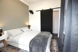 1 dormitorio con cama blanca y ventana en The Pavilion End - Central Paddington Apartment en Sídney