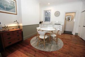 eine Küche mit einem Tisch und Stühlen im Zimmer in der Unterkunft The Pavilion End - Central Paddington Apartment in Sydney